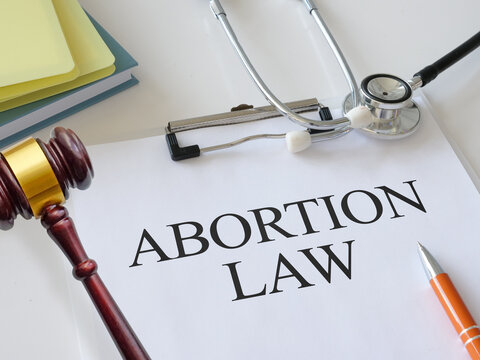Abortion law concept. Pregnancy termination ban. Judge gavel and Abortion Law book