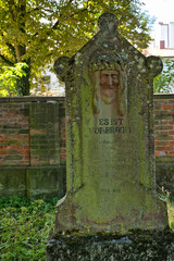 Es ist Vollbracht auf einem sehr alten Grabstein mit dem Antlitz von Jesus auf einem Waldfriedhof in Memmingen © Blende8