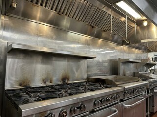 Commercial Kitchen Stainless Steel Equipment with Exhaust Hoods and Stoves.