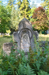 alter stark verwitterter Grabstein auf einem Waldfriedhof in Memmingen © Blende8
