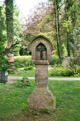 sehr alter Grabstein mit einem kreuz auf dem Waldfriedhof in Memmingen © Blende8