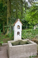 sehr schöner alter Brunnen Wasserstelle in Form eines Hauses  auf dem Walfriedhof Memmingen © Blende8