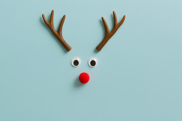 Festive reindeer face with antlers, googly eyes, and a red pom pom nose evokes holiday cheer, perfect for Christmas cards, invitations, and social media posts