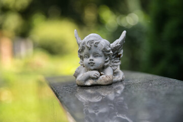 schöne Putte, kleiner Engel auf einer Mauer auf einem Friedhof in Ulm © Blende8