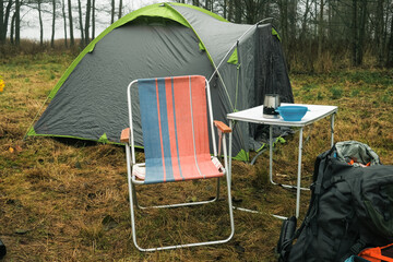 Lakeside camping scene, Camp setup by tranquil waters, Arranged campsite area near peaceful lake forest. Serene campsite prepared for outdoor meal experience. Quiet. Campground basic cooking amenities