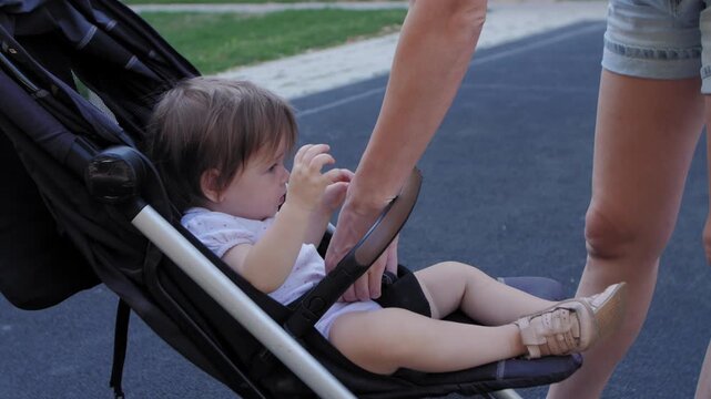 Mother hugging her baby girl after taking her from a stroller