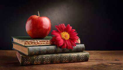 red apple and flower on vintage books with dark backround