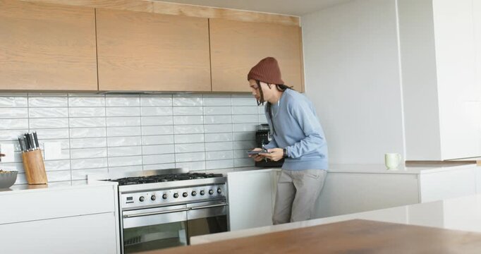 African American man checking knobs in kitchen, tapping tablet turning cabinet lighting, copy space