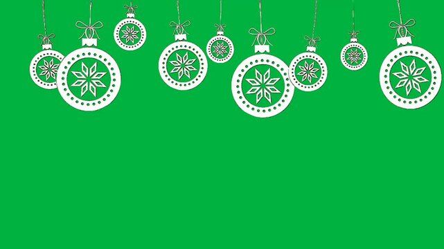 White Christmas ornaments with intricate snowflake designs suspended against a vibrant green background.
