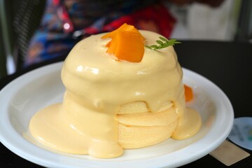 Fluffy souffle pancake topped with mango cream and fruit. Fancy dessert in Shenzhen, China.