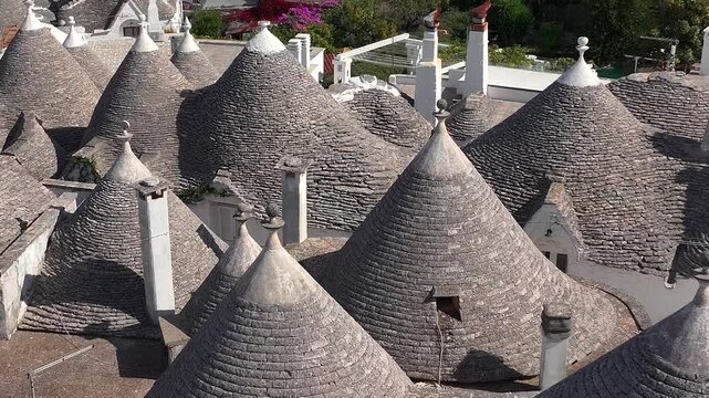 Traditional Trulli Rooftops, Aerial Shot of Unique Conical Roofed Houses of Alberobello in Puglia, Italy. Sunny Day.