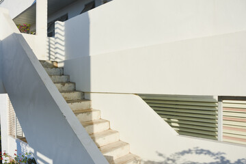 A concrete outdoor staircase with peeling paint in sunlight.