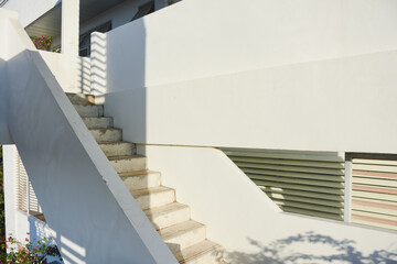 A concrete outdoor staircase with peeling paint in sunlight.