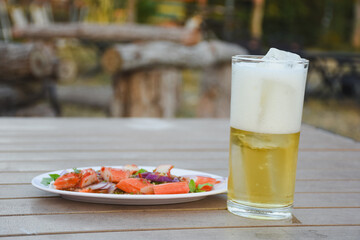 Crab salad and cold beer on a wooden table.