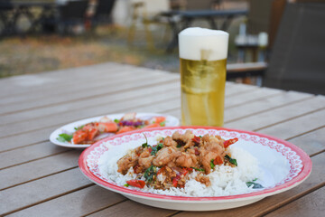 Spicy Thai salad with crab and cold beer on a wooden table.