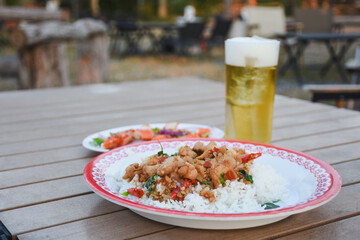 Spicy Thai salad with crab and cold beer on a wooden table.
