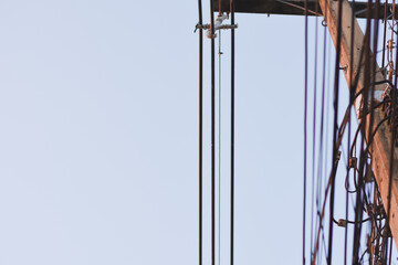 A close-up of vertical power lines against a light sky.