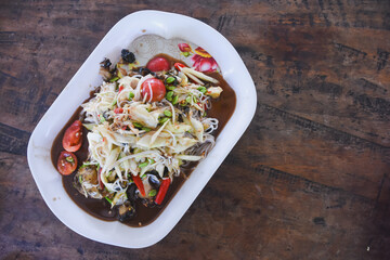Spicy Thai papaya salad (Som Tum) with noodles and crab.