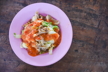 Stir-fried pork with Chinese cabbage and egg on a pink plate.