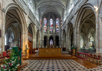 Blois, France - 10 26 2025: Saint Louis Cathedral. Panoramic view of the transept with stained glass windows and altar at the back