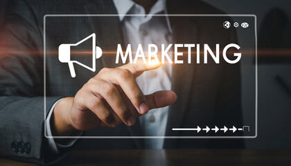 Hand pointing to a digital screen displaying the word MARKETING with a megaphone icon, symbolizing business promotion and advertising strategies for brand growth
