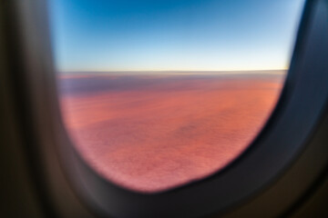 Fototapeta premium View from airplane's window above clouds during sunset