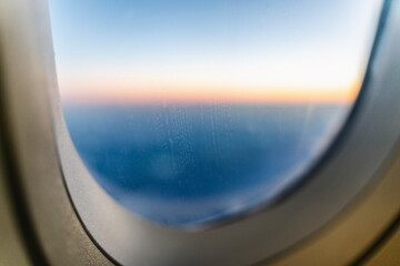 Fototapeta premium View from airplane's window above clouds during sunset