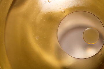 Close-up of Abstract Liquid Patterns and Light Reflections in Gold