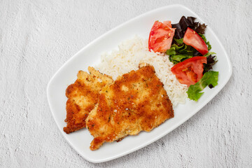 crispy breaded chicken breast with boiled rice and salad