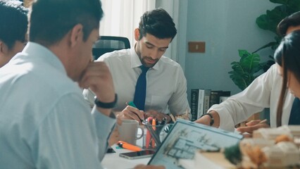Top aerial view of project manager or civil engineer writing at blueprint and planning building...