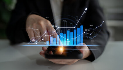 A businessperson actively engages with a smartphone, exploring digital financial data through interactive graphs and charts in a contemporary office setting. Scalp