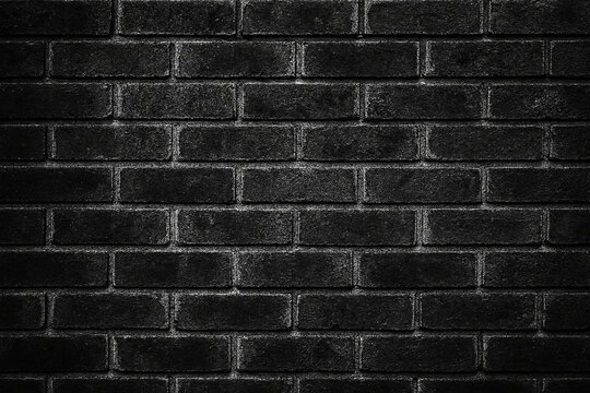 Dark textured black brick wall background with subtle white highlights and rough surface detail - Powered by Adobe