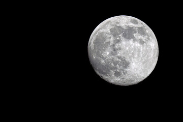 Bright full moon against black sky of space. 