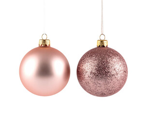 Two rose-toned Christmas ornaments suspended against a black background, festive holiday decor