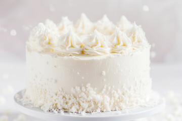 Fototapeta premium 2026 color trend. Intricately decorated white cake with delicate frosting swirls, presented on a cake stand, showcasing a delightful dessert perfect for celebrations and special occasions