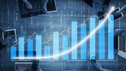 Business professionals collaborate using laptops and tablets, visualizing data analysis on digital graphs that highlight significant upward trends and market growth. Copula