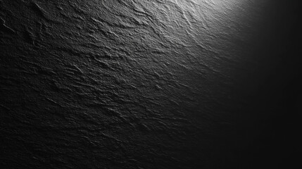 Textured black surface with dramatic lighting showcasing depth and visual interest for design