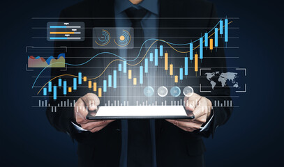 A business professional stands confidently, holding a tablet that showcases dynamic financial data...