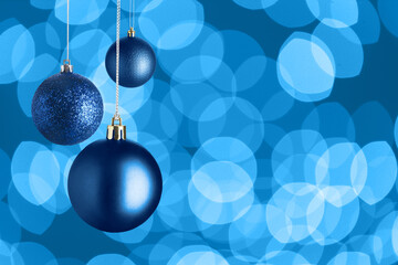 Christmas balls and bokeh lights on blue background. Happy winter holidays