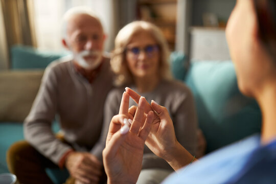 Close up of a doctor talking to senior couple during home visit - Powered by Adobe