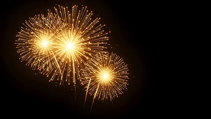 Fototapeta premium Brilliant golden yellow fireworks exploding in a dazzling display against a solid black night sky background, perfect for celebration