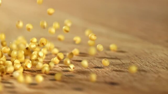 Millet groats fall on a wooden table. Filmed on a high-speed camera at 1000 fps. High quality FullHD footage