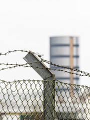 Barbed wire fence in Boras Sweden with industrial building in background during daytime