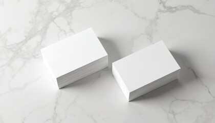 Two stacks of blank white business cards sit on clean marble surface. Empty cards perfect for custom design needs, branding projects, portfolio presentations. Use to showcase new logos contact