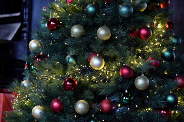 Christmas tree with decorations, fairy lights surrounded by many beautiful colored balls for Christmas and new year celebration.
