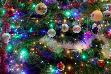 Christmas tree with decorations, fairy lights surrounded by many beautiful colored balls for Christmas and new year celebration.