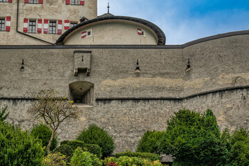 Stone fortress wall of Hohenwerfen Castle with greenery
