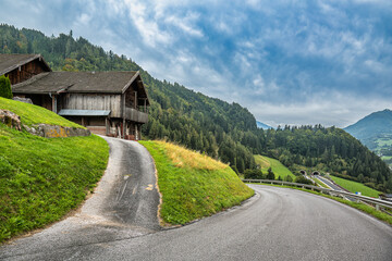 Mountain road and wooden house overlooking alpine highway in Werfen

