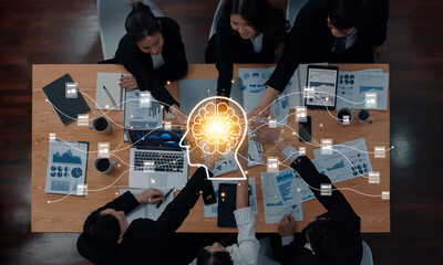 A diverse business team engages in brainstorming with a digital brain concept, showcasing collaboration, technology, and innovative ideas in a modern office environment. Trope