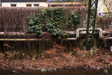 Fernw&auml;rmeleitung vor alten Industriegeb&auml;uden am Ufer der Wupper, Wuppertal, Deutschland